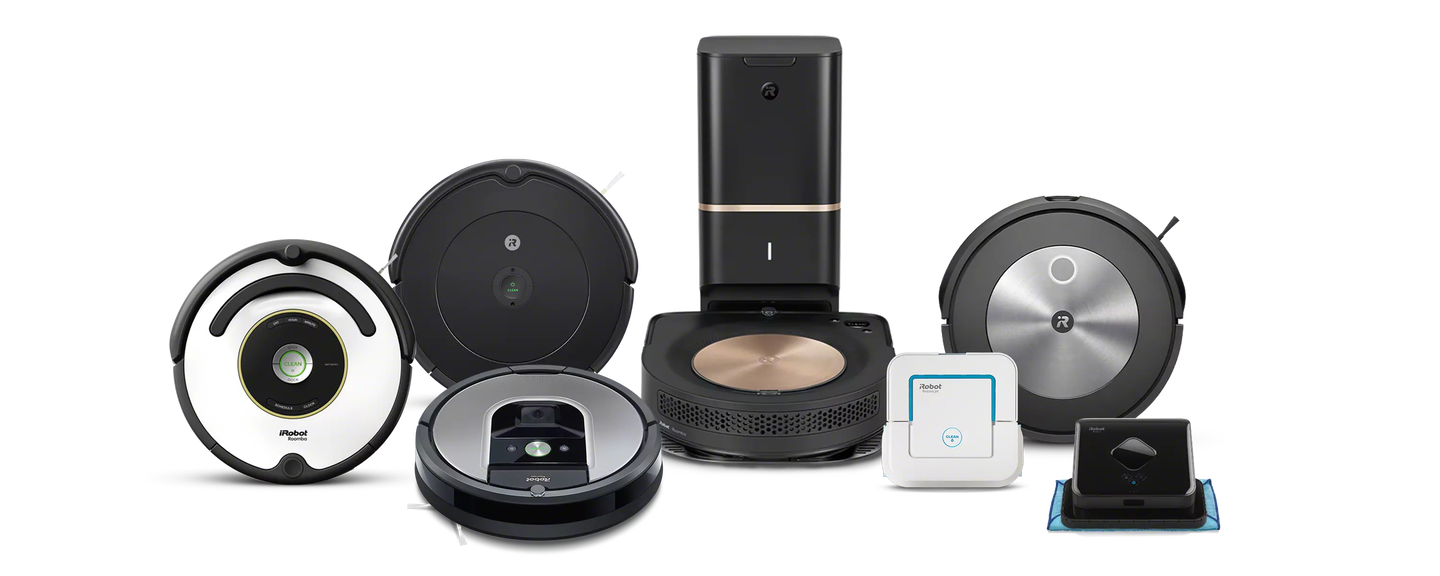 A family plays in the kitchen behind images of iRobot’s collection of robot vacuums and mops.